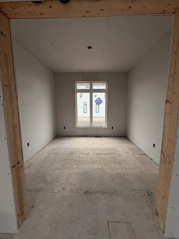 After: the same bedroom with the walls and ceiling hung in drywall